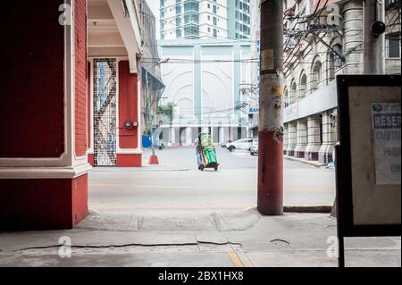 Traffic and pedestrians pass under the Filipino Chinese Friendship Arch in the Binondo District, China Town, Manila, The Philippines. Stock Photo