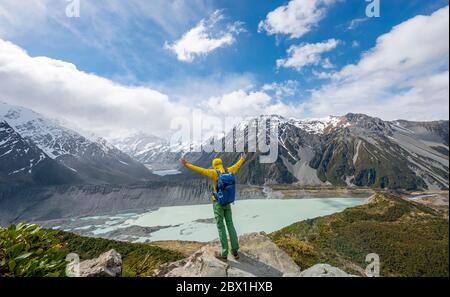 Hiker stretches his arms in the air, views of the Hooker Valley from the Sealy Tarns Track, glacial lakes Mueller Lake and Hooker Lake, Mount Cook Stock Photo