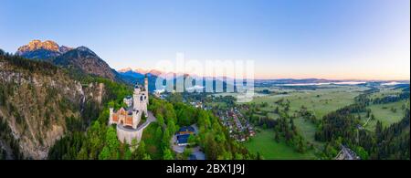 Panorama, Neuschwanstein Castle, Mount Saeuling in the morning light, Hohenschwangau Castle, on the right Forggensee, near Schwangau, drone shot Stock Photo