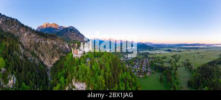 Panorama, Neuschwanstein Castle, Mount Saeuling in the morning light, Hohenschwangau Castle, on the right Forggensee, near Schwangau, drone shot Stock Photo