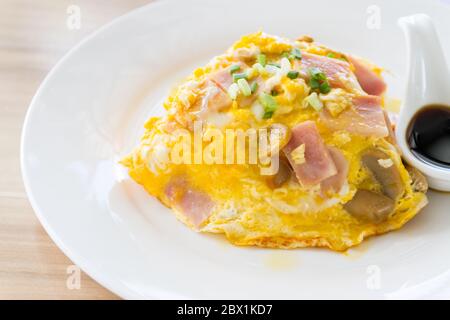 Scrambled omlette eggs with pork ham on rice. Stock Photo