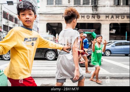 Poor Filipino street children play at a busy junction in the China Town ...