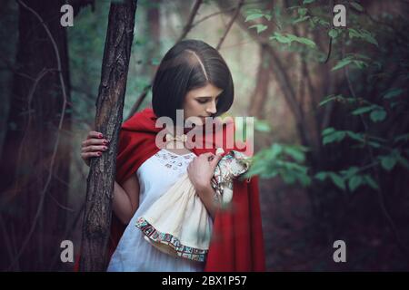 Beautiful woman and her doll lost in the wood . Fantasy and surreal Stock Photo