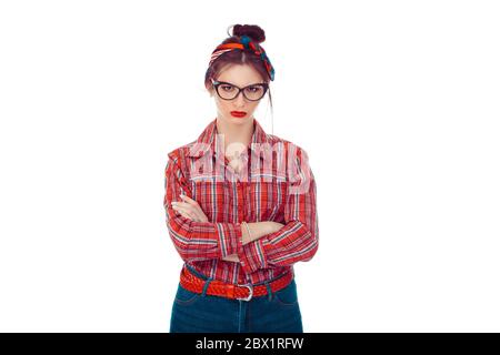 Upset woman looking at camera. Closeup portrait of a beautiful girl in red checkered shirt and jeans with retro bow on head isolated on pure white bac Stock Photo