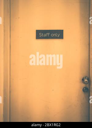 Staff only sign on a old door. Vintage tone Stock Photo