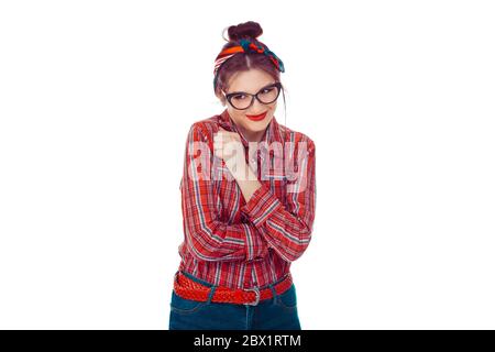 Lack of confidence. Shy young woman feels awkward. Closeup portrait of a beautiful girl in red checkered shirt and jeans with retro bow on head isolat Stock Photo