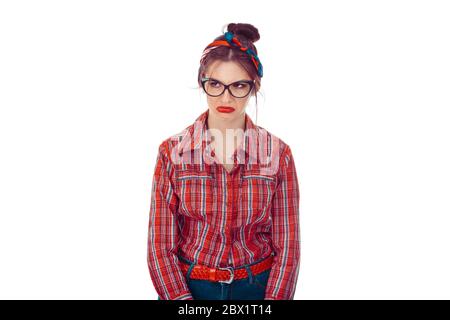 Upset woman looking to the side. Closeup portrait of a beautiful girl in red checkered shirt and jeans with retro bow on head isolated on pure white b Stock Photo