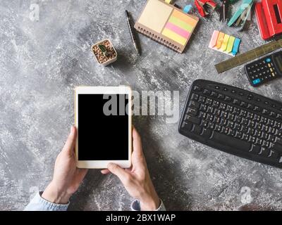 Top view of Male hands using Tablet with Office supplies on grunge gray background Stock Photo