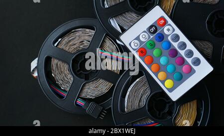 Three Led strip coils closeup. Diode with control panel for switching colors on dark background. Stock Photo