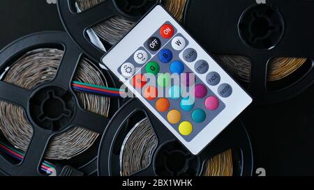 Three Led strip coils closeup. Diode with control panel for switching colors on dark background. Stock Photo