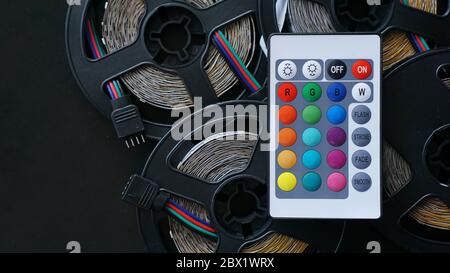 Three Led strip coils closeup. Diode with control panel for switching colors on dark background. Stock Photo