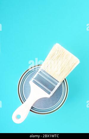Paint brush with natural bristles for paint and metal can on blue background. House renovation. Hobby. Color therapy Stock Photo