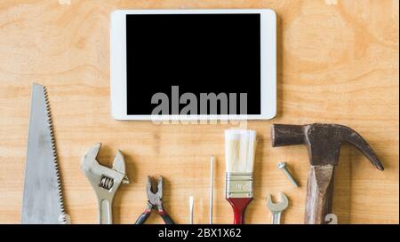 Set of different work tools with tablet on wooden table background. Stock Photo