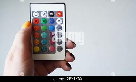 Remote control for change colors in hand isolated on white background Stock Photo