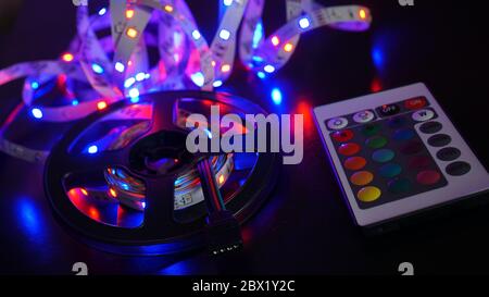 LED strip in purple colors and a control panel for switching colors. Dark background Stock Photo