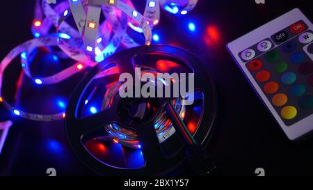 LED strip in purple colors and a control panel for switching colors. Dark background Stock Photo