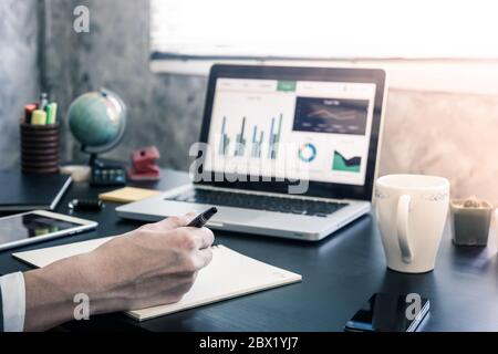 Businessman analyzing investment charts on the office desk. Stock Photo
