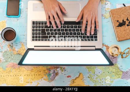 Top view female hands using laptop on world map booking next travel destinations - Young trip agent woman browsing online Stock Photo