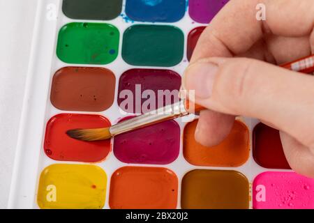 Closeup of watercolor painting process. Paintbrush taking color from inf  palette. Colorful medieval city street on paper board Stock Photo - Alamy