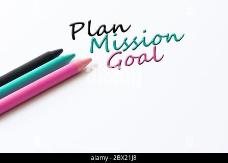 Words Plan, Mission, Goal and colored crayons on white background. Hand writing business process concept. Stock Photo