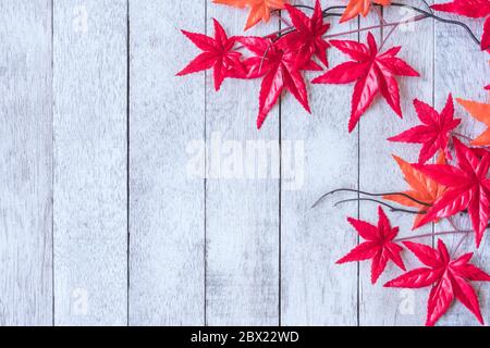 Maple leaves on white painted wood plank background. Stock Photo