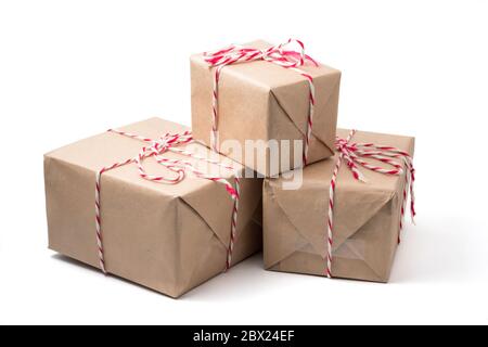 Gift packages wrapped in brown paper on white background. Stock Photo