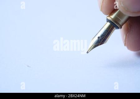 Fountain pen in the hand on the white paper Stock Photo