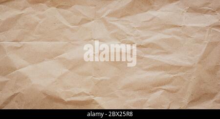 Crumpled brown paper texture, background. Messy wrinkled parchment pattern. Craft rustic sheet, old wrapping card Stock Photo