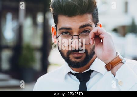 Stylishly dressed Indian bearded man walks down the street. Stock Photo