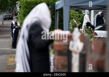 Manchester, UK. 4th June, 2020. Orthodox Jewish men conduct their morning prayers in adjacent gardens in Salford so as to comply with new rules allowing 6 people to congregate in one garden but still achieve a minyan, a quorum of ten Jewish adults required for certain religious obligations, Manchester, UK. Credit: Jon Super/Alamy Live News. Stock Photo