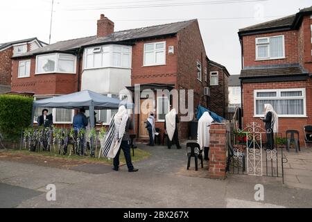 Manchester, UK. 4th June, 2020. Orthodox Jewish men conduct their morning prayers in adjacent gardens in Salford so as to comply with new rules allowing 6 people to congregate in one garden but still achieve a minyan, a quorum of ten Jewish adults required for certain religious obligations, Manchester, UK. Credit: Jon Super/Alamy Live News. Stock Photo