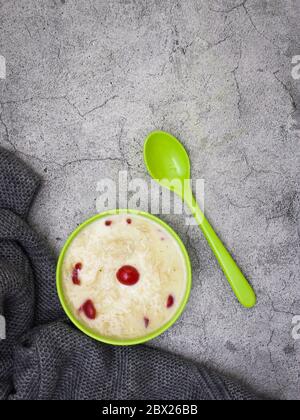 Sewai or kheer consumed on eid or indian festivals. Served with red cherry toppings in a green bowl. Stock Photo