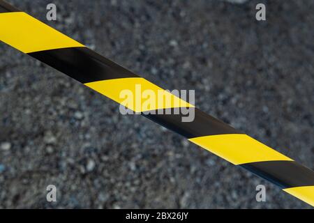 Black and yellow striped tapes on dark background. Restricted area border. Passage is forbidden. Stock Photo