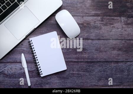Top view of laptop, notepad and computer mouse on table  Stock Photo