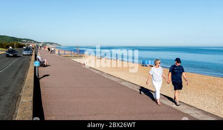 A Middle aged Couple walking along the Beach in The Hythe Kent Stock Photo