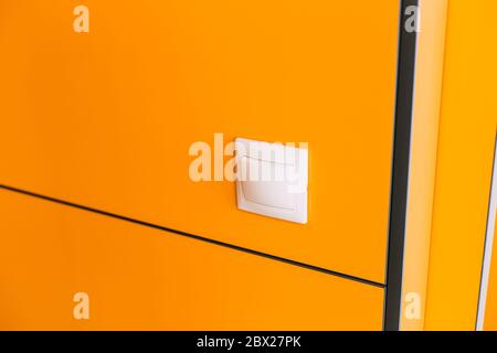 white light switch on a yellow wall Stock Photo