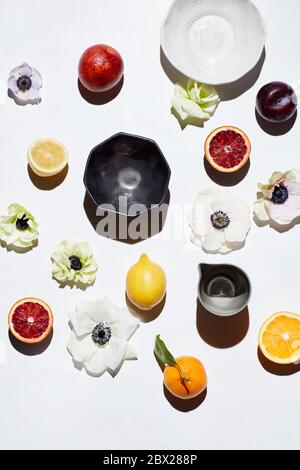 Still life with ceramic bowls, fruits and flower pedals Stock Photo
