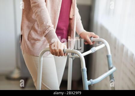 Close-up of senior woman using walker while moving along the room at home Stock Photo