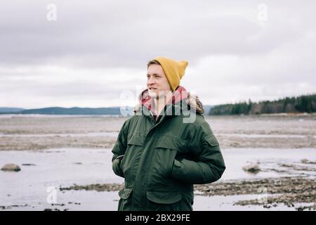 portrait of a man smiling whilst standing alone in the great outdoors Stock Photo