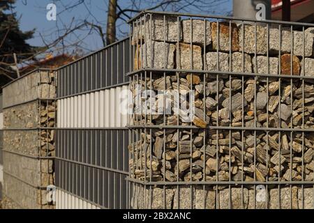 Gabions. An interesting example of fencing, metal baskets filled with different rock material. Stock Photo