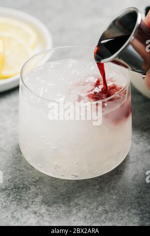 Pouring Creme de Cassis into a Bramble cocktail Stock Photo