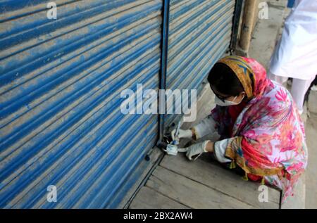 Additional Assistant Commissioner for Peshawar Cantonment, Gulshan Ara sealed the shops in different areas against the violating of SOPs, as a preventive measures against the spread of the coronavirus (COVID-19), in Peshawar on Thursday, June 4, 2020. The number of confirmed COVID-19 cases in Pakistan rose to 86,931 on Thursday after new infections were confirmed in the country. Stock Photo