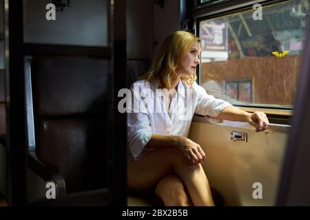A woman looking out of the window on a train Stock Photo