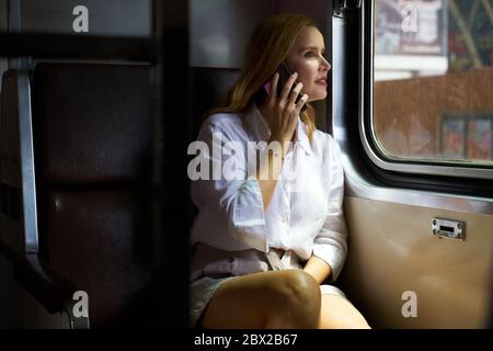 A woman using a smart phone on a train Stock Photo