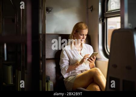 A woman using a smart phone on a train Stock Photo