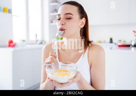 Closeup photo of pretty housewife lady sit morning kitchen have breakfast eat cereal corn flakes milk lick spoon stay home distance remote work good Stock Photo