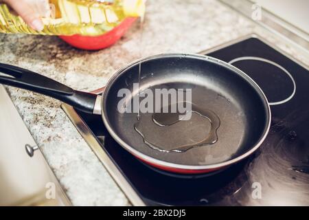 thin stream of sunflower oil in a hot frying pan Stock Photo
