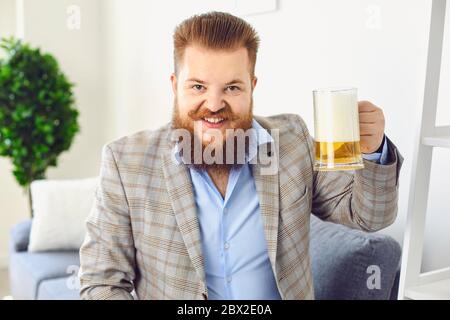 Online looking at camera. Funny man with a glass of beer smiles at friends online video chat call webcam conference home application. Stock Photo