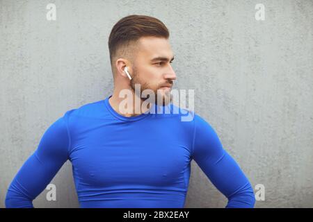 Bearded guy in sportswear on gray background. Stock Photo
