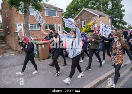 Staines, Surrey, UK. 4th June 2020. Several hundred young local residents march around Staines from the council offices with placards and shouting 'Black Lives Matter' and 'I can't Breathe' in protest against the death of George Floyd and others who have died at the hands of police in the USA and here in the UK. They 'took the knee' at the side of the old Town Hall before marching down the High St into the Two Rivers shopping park where they staged a silent die-in for 8 minutes 46 seconds, the time Floyd was restrained by a police officer. Peter Marshall/Alamy Live News Stock Photo